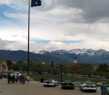 Car show with mountains in the background